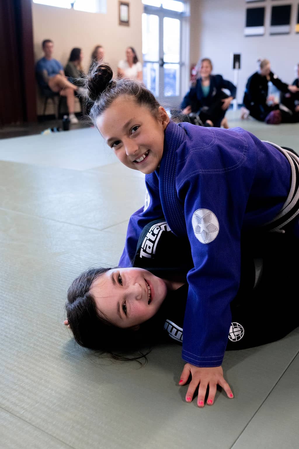 The Jiu Jitsu Institute young students smile at camera during class
