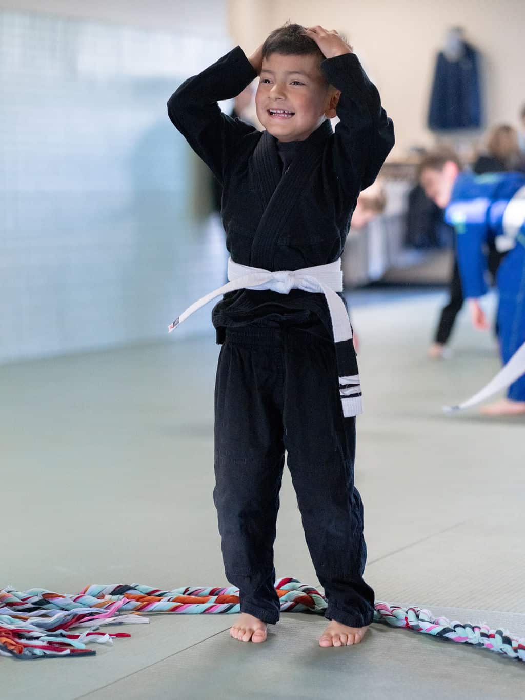 The Jiu Jitsu Institute young student standing with hands on his head during class