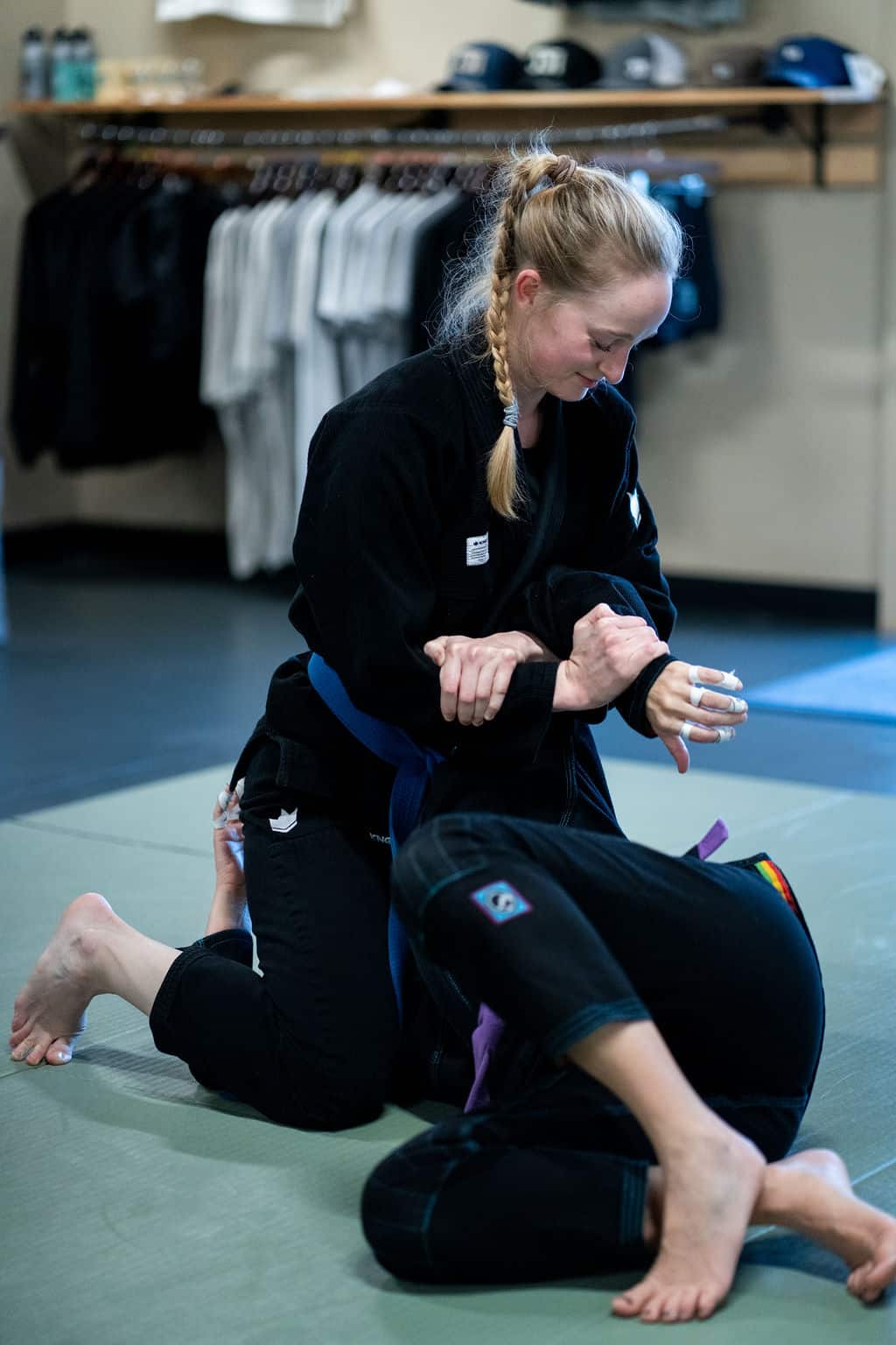 female Jiu Jitsu Institute student sparring with another student during jiu jitsu class
