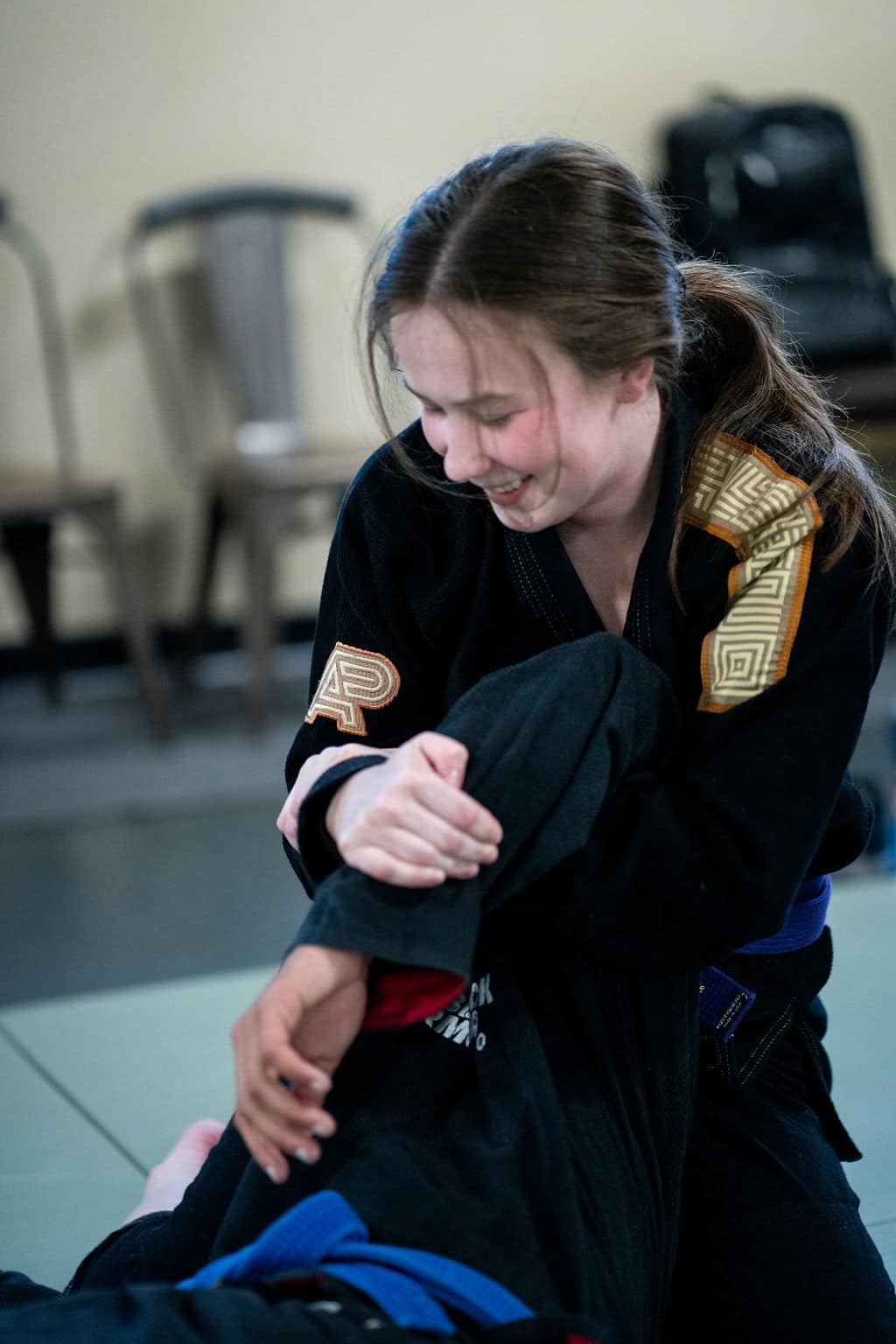 female Jiu Jitsu Institute student grappling another student during jiu jitsu class
